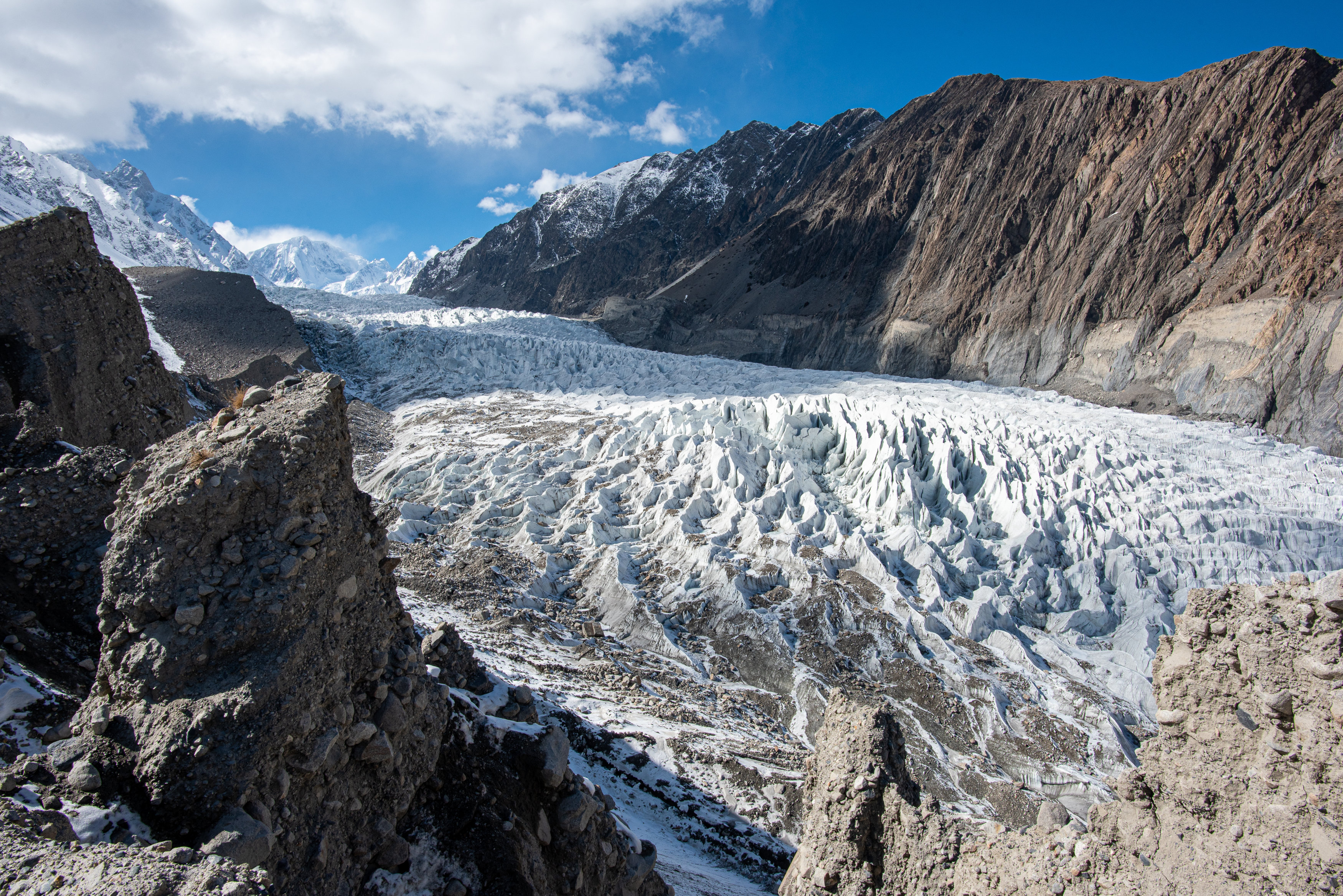 Die Eismasse eines Gletschers liegt zwischen zwei Bergketten.